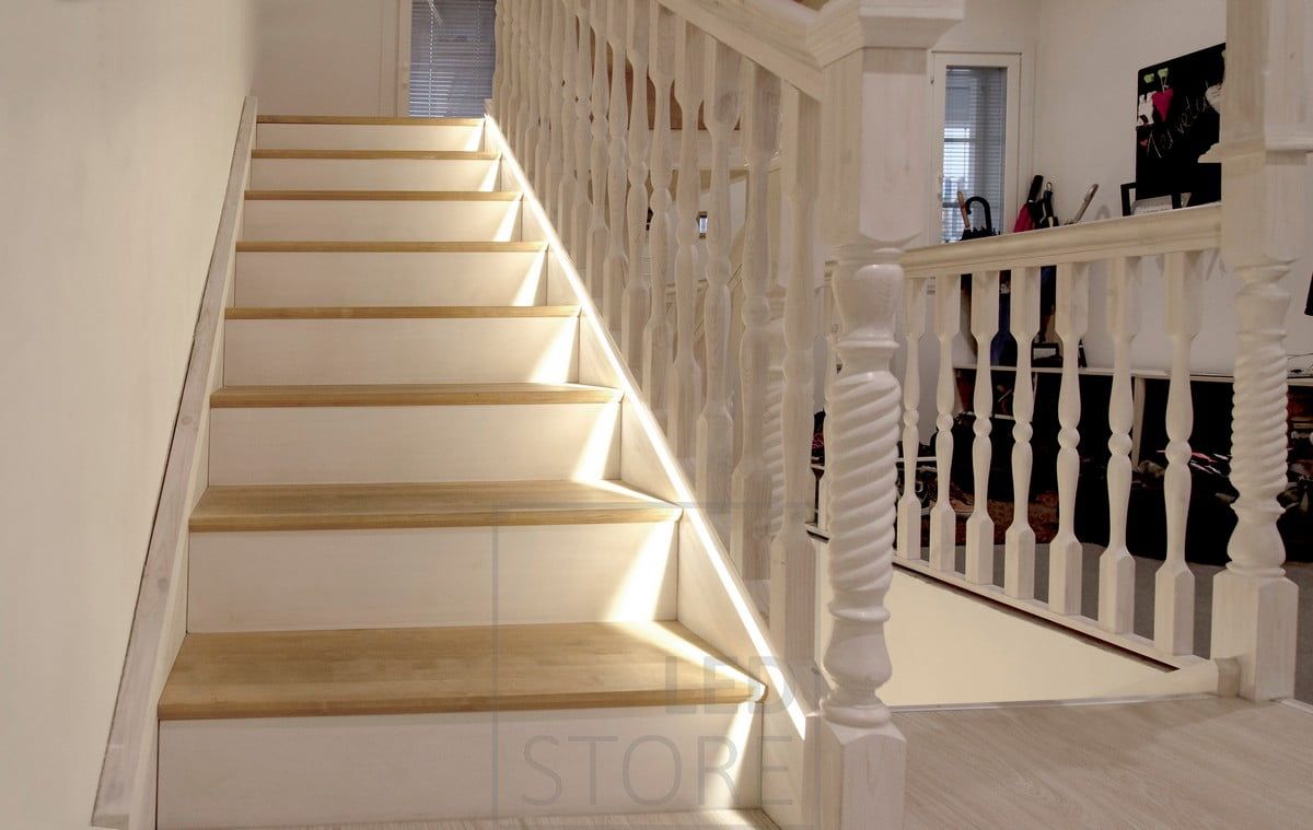 Led ribbon in a flush profile milled at the bottom of the stair handrail, as close as possible to the steps.